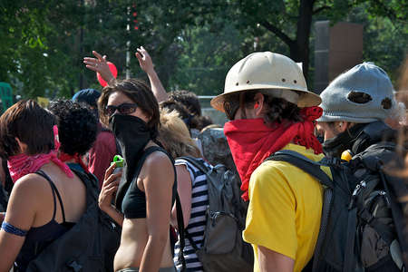 Toronto, Ontario, Canada - 06/25/2010: Crowd of multi-ethnic men and woman with face mask walking on...