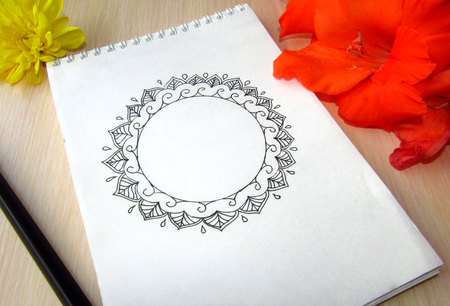 The white notebook with yellow and red flowers on the tableの写真素材