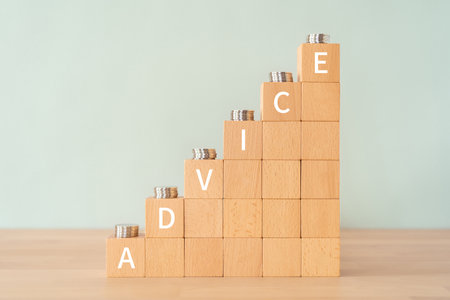 Wooden blocks with "ADVICE" text of concept and coins.の写真素材