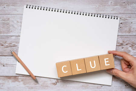 CUE word on wooden cubes with notebook and pencil on wooden backgroundの写真素材