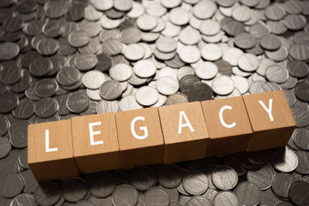 Wooden blocks with "LEGACY" text of concept and coins.の写真素材