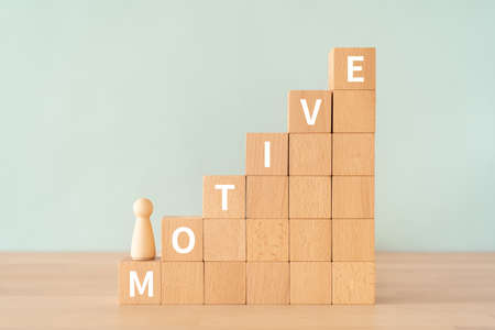 Wooden blocks with "MOTIVE" text of concept and a human toy.の写真素材