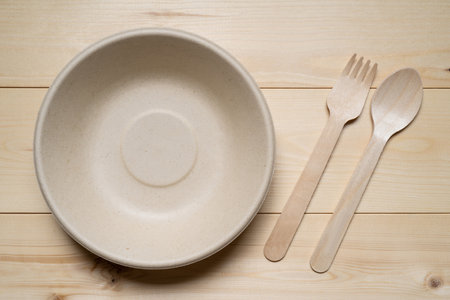 Empty plate, spoon and fork on wooden background. Top view.の写真素材