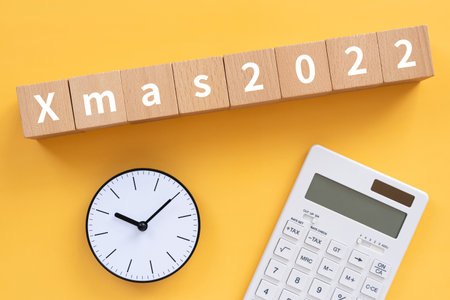 Wooden blocks with "Xmas2022" text of concept, a pen, and a notebook.の写真素材