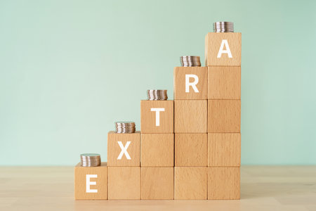 Wooden blocks with "EXTRA" text of concept and coins.の写真素材