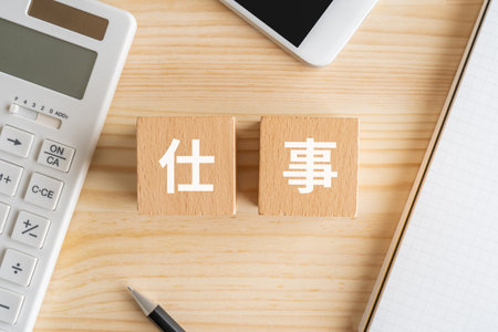 High angle view of wooden blocks with chinese characters on them and calculator on deskの写真素材