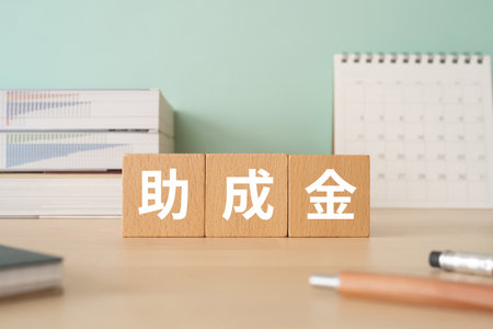 Wooden blocks with "joseikin" text of concept, pens, notebooks, and books.の写真素材