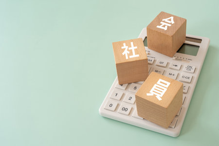 Wooden blocks with "kaishain" text of concept and a calculator.の写真素材