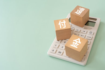 Wooden blocks with "kanpukin" text of concept and a calculator.の写真素材