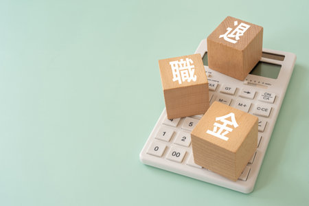 Wooden blocks with "taishokukin" text of concept and a calculator.の写真素材