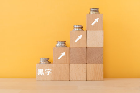 Wooden blocks with "kuroji" text of concept and coins.の写真素材