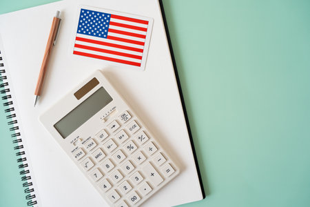 The card of the American flag, calculator, pen and notebookの写真素材