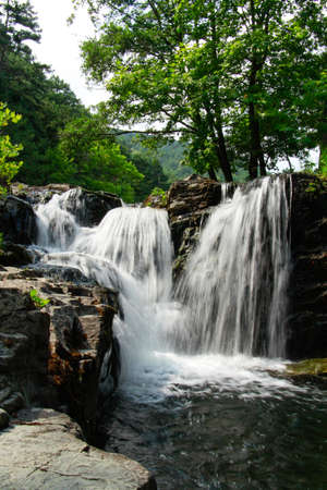 The waterfall cave beautiful. Lush green forest with waterfall.の写真素材