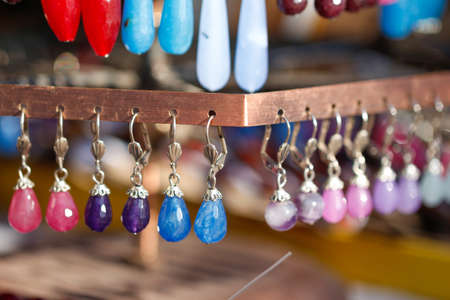 Hanging earrings in the shop. Colorful earrings. Glass earrings. Stone earrings.