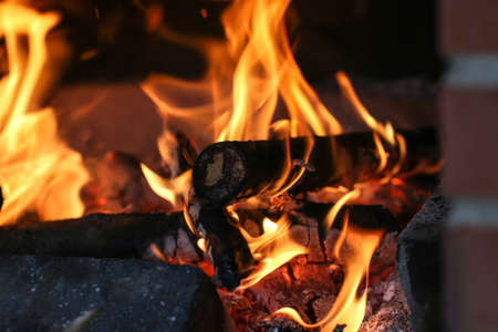 Close up shot of burning firewood in the fireplace in the house. Cosiness.