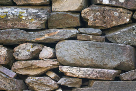 Natural stonewall texture for background. Stone wall built from stones and rocks of different sizes.