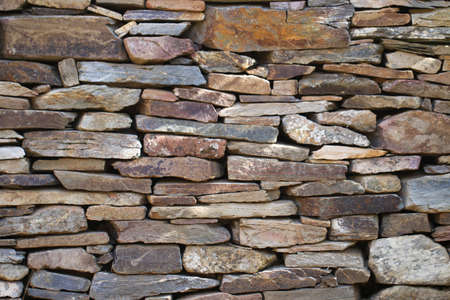 Natural stonewall texture for background. Stone wall built from stones and rocks of different sizes.の写真素材