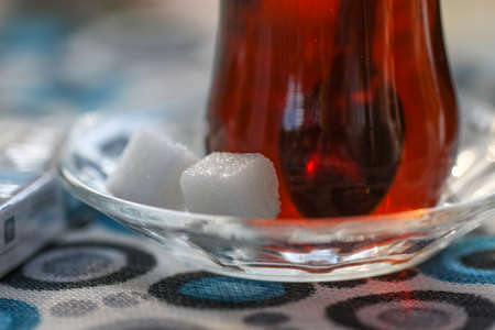 Close up of two sugar cubes above a Turkish tea in traditional glass.の写真素材