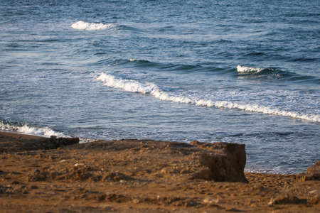 Sea foam with small wave and beach.