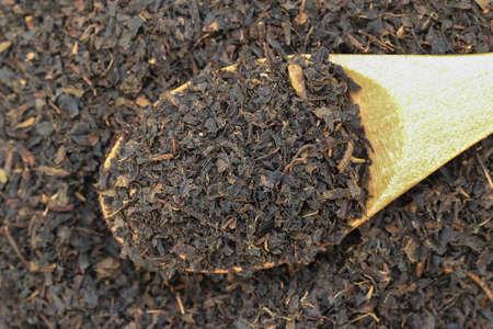 Dry black tea on a wooden spoon.の写真素材