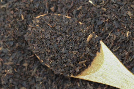 Dry black tea on a wooden spoon.の写真素材