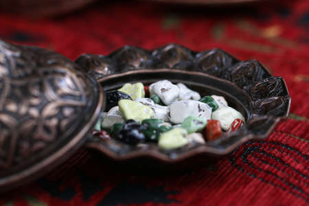 Multi colored candies.Chocolates stones in a antique bowl.の写真素材