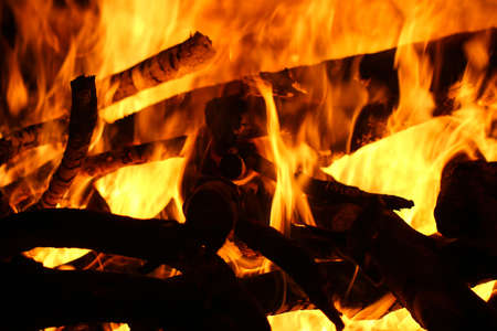 Closeup of a large fire. Wooden planks to the fire. The fire is lit in the night.の写真素材