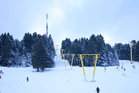 Skiing at the ski resort. Uludag is the ancient Mysian Olympus and Bithynian Olympus, a mountain in Bursa Province, Turkey. Ski lifts durings bright winter day.の写真素材