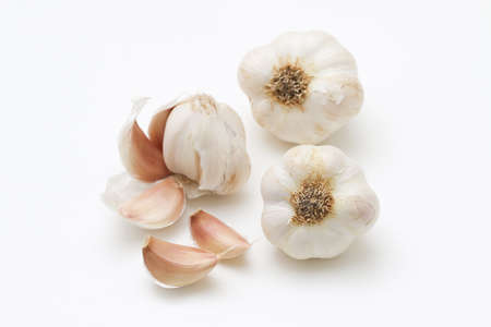 Close up of bulb of garlic and cloves of garlic on a white background.の写真素材