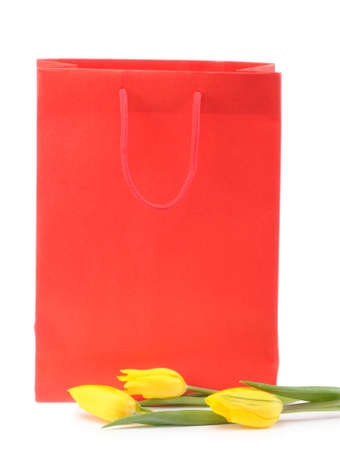 Yellow tulips with a gift bag isolated on white backgroundの写真素材