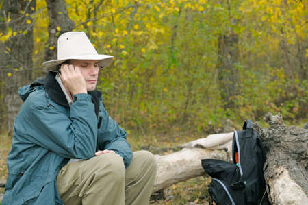 Man  with a mobile phone in autumn forest