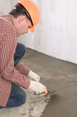 Construction worker spreading wet concreteの写真素材