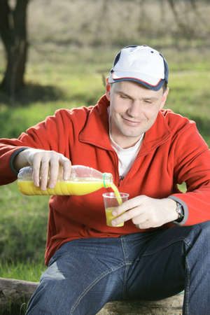 Man drinking orange juice outdoors