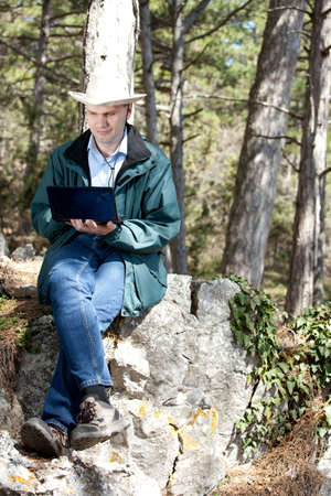 Man with laptop in forest