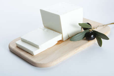 Feta cheese with olive on a wooden cutting boardの写真素材