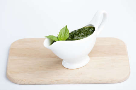 Pesto sauce in white saucer with basilの写真素材