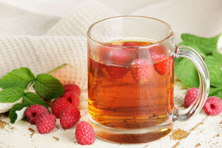 Glass of tea with fresh raspberryの写真素材