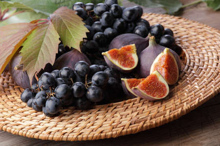 Figs and grapes in rustic plateの写真素材