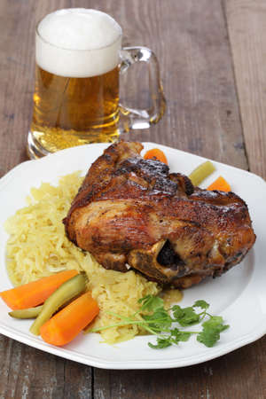 Eisbein with sauerkraut and beer on white plateの写真素材