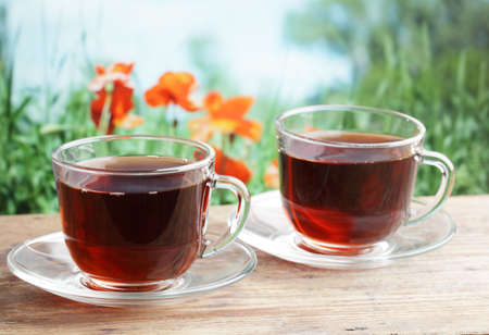 Two cups of black tea on a wooden tableの写真素材