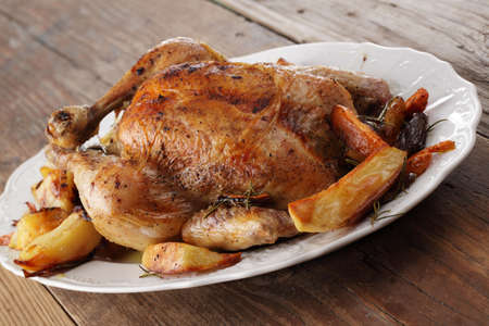 Roasted turkey with vegetables on white serving dishの写真素材