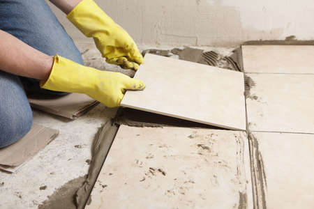 Tiler installing ceramic tiles on a floorの写真素材
