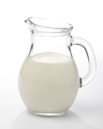 Glass jug with milk against white backgroundの写真素材