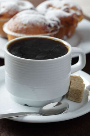 Cup of black coffee against muffins