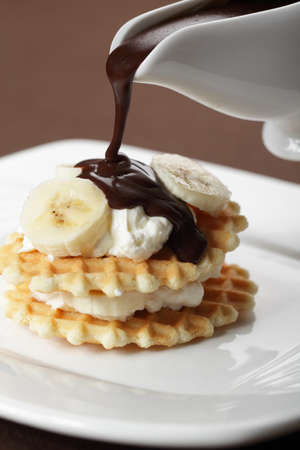 Waffle with Greek yogurt and banana under chocolate sauce closeupの写真素材