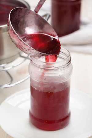 Pouring red currant jelly into the jar