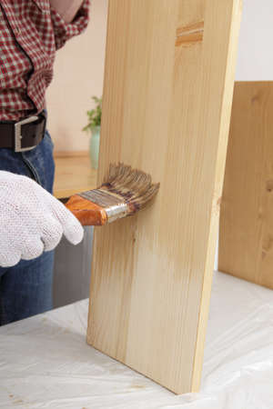 Man varnishing a wood plankの写真素材