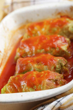 Stuffed cabbage with tomato sauce in white casseroleの写真素材