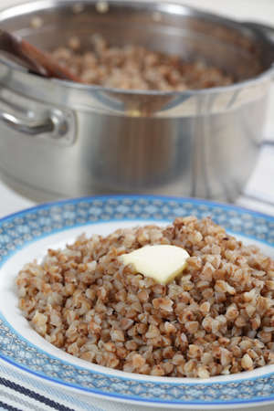 Buckwheat cereal with butter on the plate and in the panの写真素材