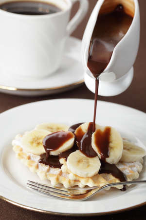 Waffle with banana under chocolate sauce closeupの写真素材